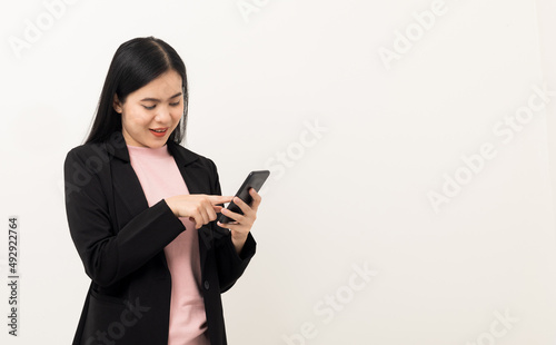 Cheerful young Asian woman using smartphone and checking message on mobile chat application isolated white background. Fashion style asian lovely woman playing game or shopping online by cellphone