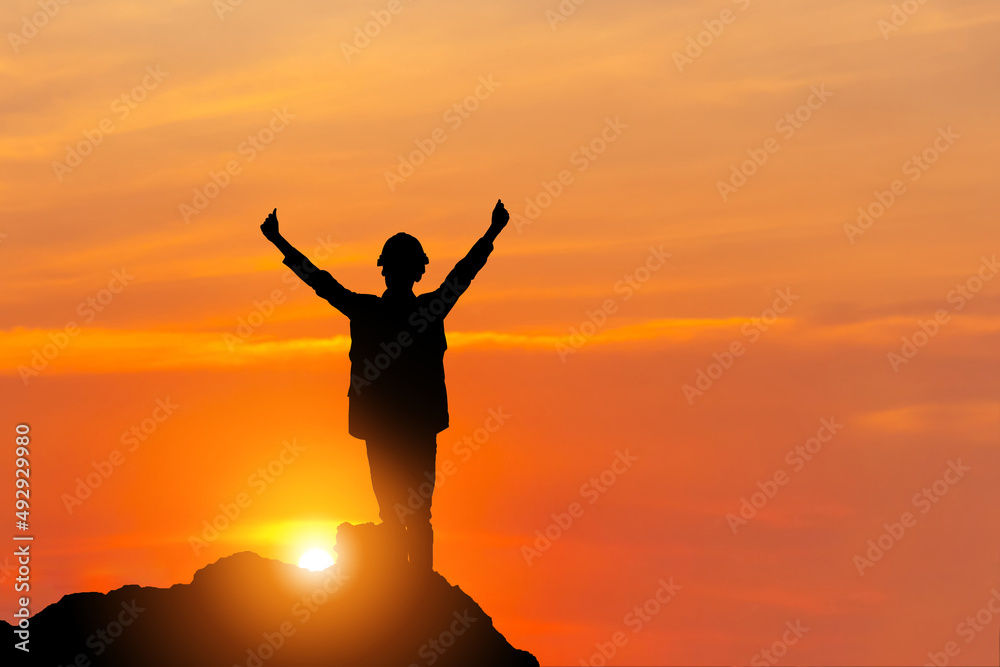Silhouette of man in hard hat with clipping path celebration success on a mountain top sunset sky background Silhouette of man in hard hat with clipping path celebration success on a mountain top sunset sky background