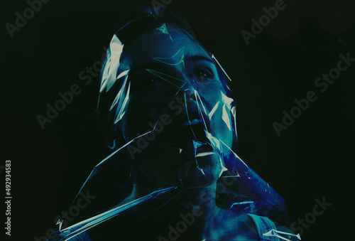 Taking her last breath. A young woman suffocating with her head wrapped in plastic while isolated on a black background.