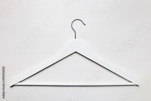 White Wooden empty coat hanger with metal hook top view white wooden table background