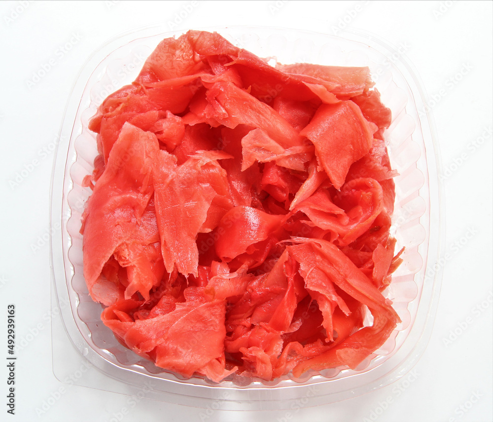 Pickled pink ginger in a plastic container. Portioned ginger for sushi. Pickled pink ginger in a plastic container. Portioned ginger for sushi.