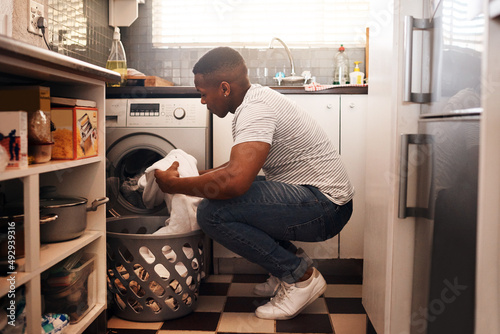 I always do laundry on the weekend. Shot of a man doing the laundry at home.