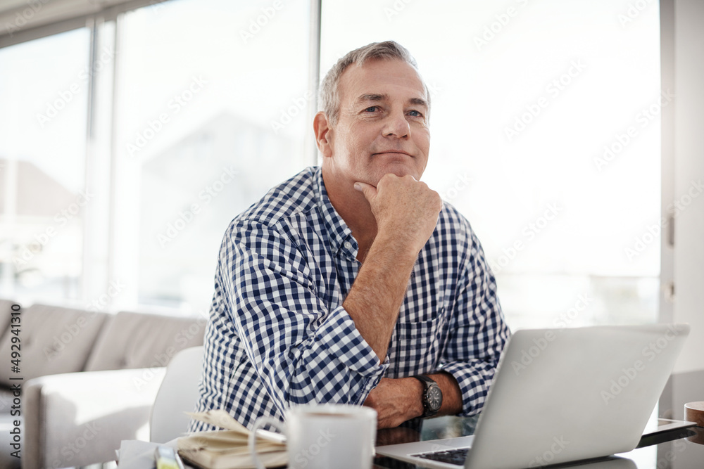 The internet keeps me connected to all I need. Portrait of a mature man working on a laptop at home. The internet keeps me connected to all I need. Portrait of a mature man working on a laptop at home.