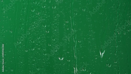 Water rainfall, rain drops falling on window glass over chroma key green screen