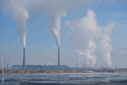 Smoke escapes from pipes and cooling towers at a thermal power plant