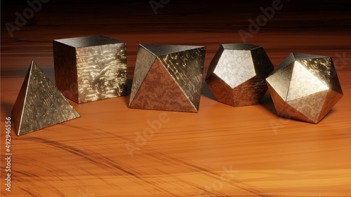 Platonic solids - tetrahedron, cube, octahedron, dodecahedron and icosahedron (set of scratched metal polyhedra on a worn wooden surface) photo