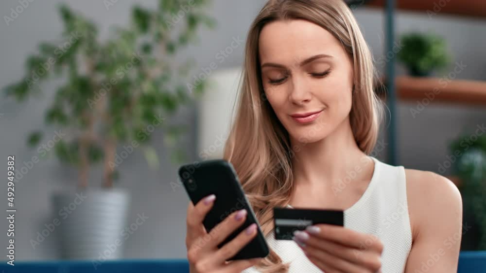 Beautiful young blonde woman paying card smartphone application enjoy online shopping closeup Beautiful young blonde woman paying card smartphone application enjoy online shopping closeup