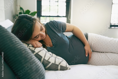 I want to hold you in my arms already. Shot of a young pregnant woman relaxing at home.