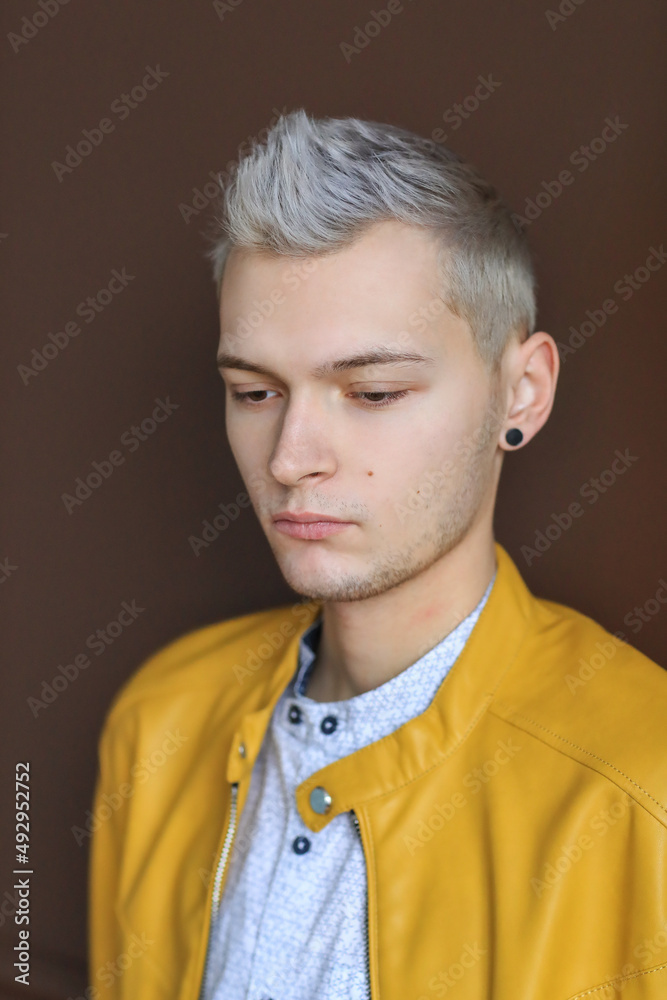 Headshot portrait of attractive confident man looking at camera sitting on couch at modern living room. Headshot portrait of attractive confident man looking at camera sitting on couch at modern living room.