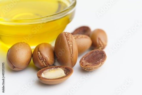 Argan seeds and oil isolated on a white background. Argan oil nuts with plant. Cosmetics and natural oils background