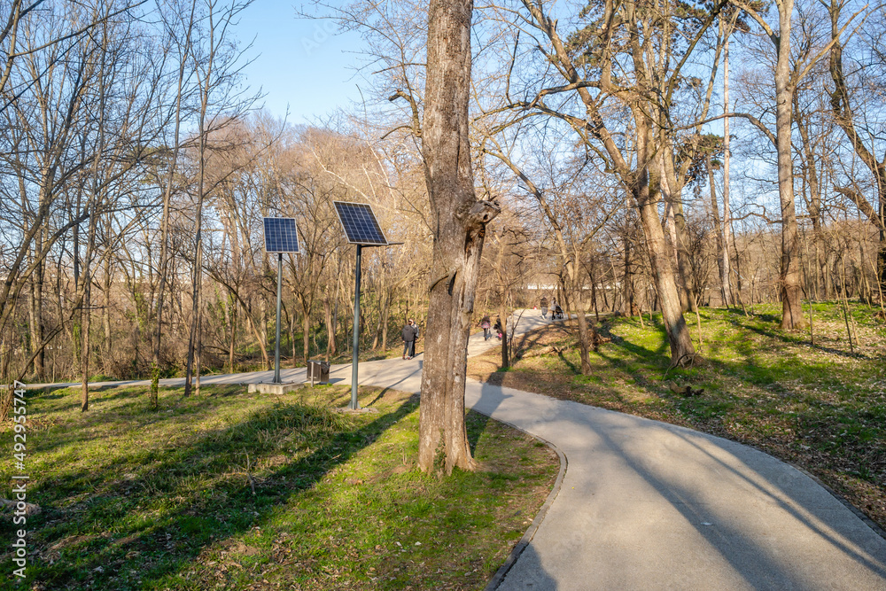 Sunny day on the promenade in the city park . Solar panels of the alternative energy system have been installed on the promenade in the city park in Kamenica, near the city of Novi Sad.