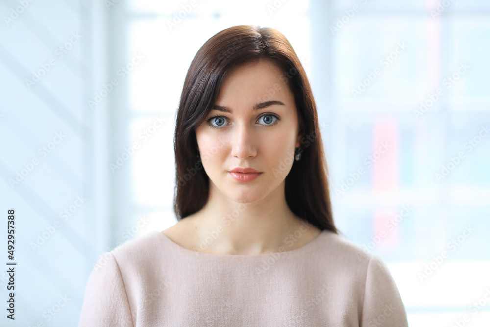 Stylish attractive young businesswoman with a lovely smile standing in the office grinning at the camera Stylish attractive young businesswoman with a lovely smile standing in the office grinning at the camera