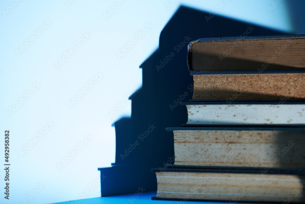 stack of books with shadow against blue background stack of books with shadow against blue background