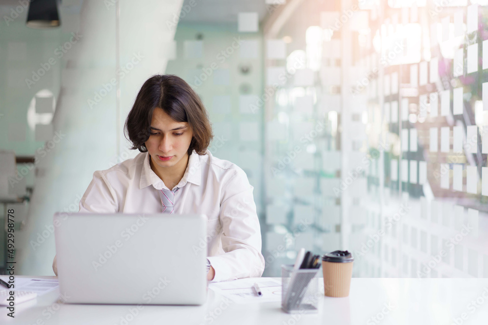 Business concept, Businessman analyzing statistical to typing financial report on laptop in office Business concept, Businessman analyzing statistical to typing financial report on laptop in office