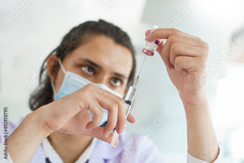 Vaccination concept  Male doctor in medical mask preparing vaccine against covid-19 for people