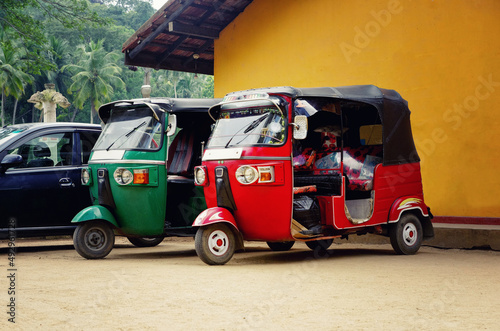 Tuk-tuk cars parked in the street of Sri Lanka. Famous tuk tuk taxi cars. Green and red tuk tuk.