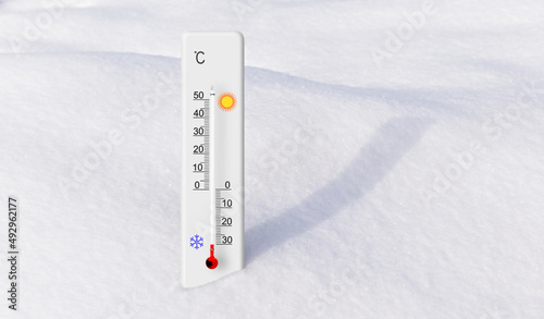 White celsius scale thermometer in the snow. Ambient temperature minus 30 degrees photo