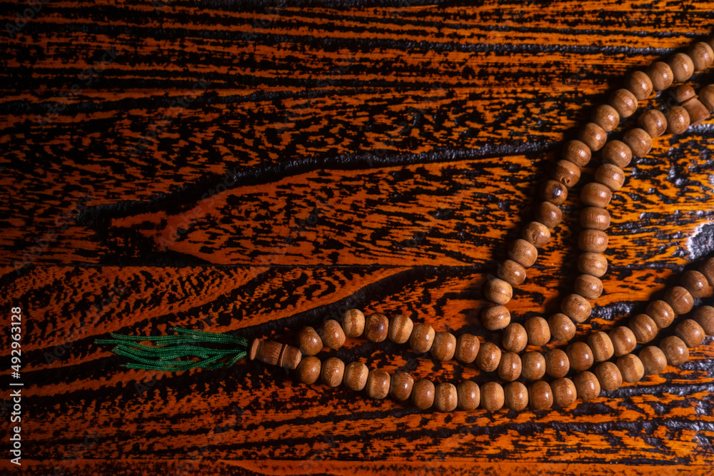 Obraz premium close up of wood tasbih with blur bokeh on wooden background. Wooden rosary