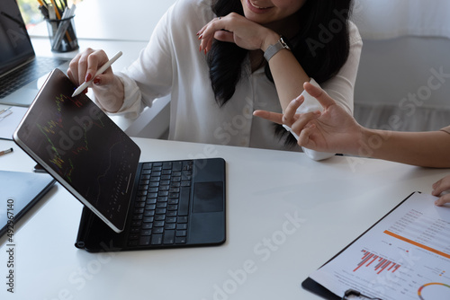 Obraz na plátně Woman investing in world stock market, using her laptop and online trading soft