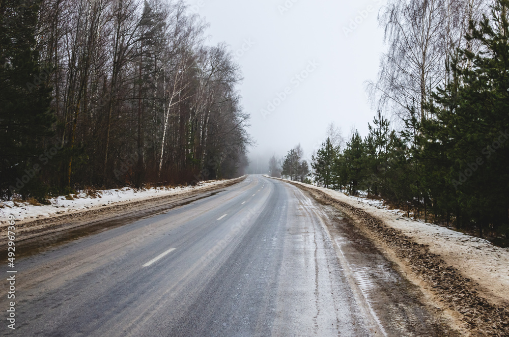 The road stretching into the distance in winter in cloudy weather The road stretching into the distance in winter in cloudy weather