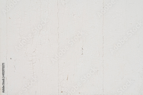 Texture d'un mur en bois peint en blanc dont la peinture est écaillée