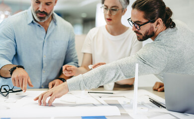 Designers working with blueprints in an office