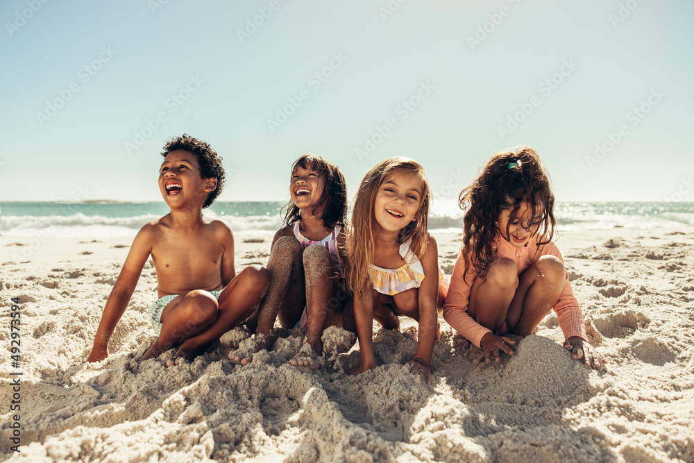 Four young friends having fun on beach sand Four young friends having fun on beach sand