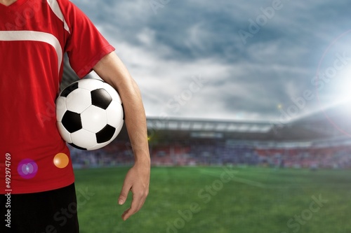 Happy young man football fan in t-shirt cheer up support favorite team hold soccer ball