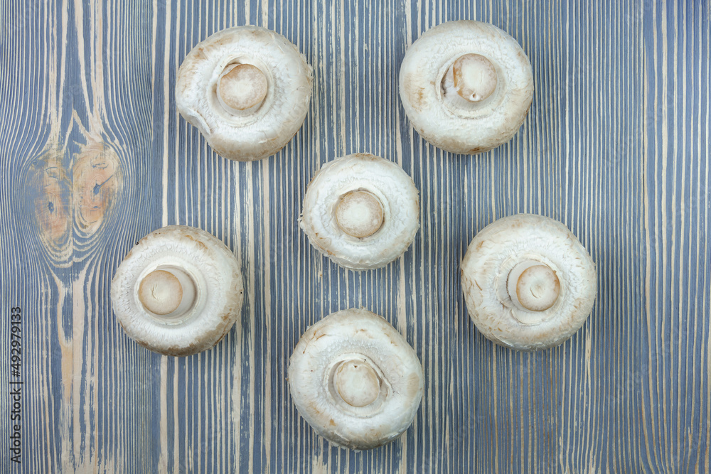 Obraz premium Champignon mushrooms on a wooden table.