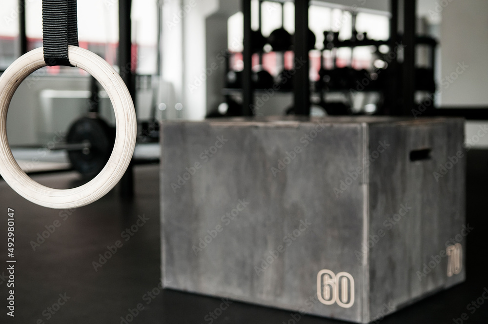 Gymnastics ring in focus with box and functional training gym interior in background