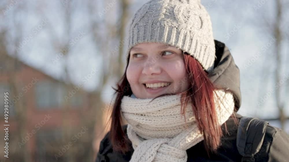 Close-up happy young girl in sunny weather, portrait of girl smiling at camera in park, slow motion