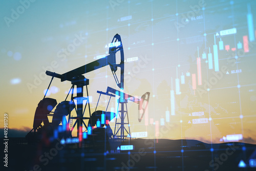 Abstract backlit oil pumping equipment on sky background with glowing growing candlestick forex chart. Trade, finance and economy concept. Double exposure. photo