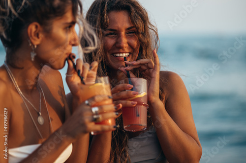 Photography Attractive friends enjoying vacation together on the beach and drinking cocktail