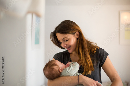 New Mum cradling her baby and smiling photo