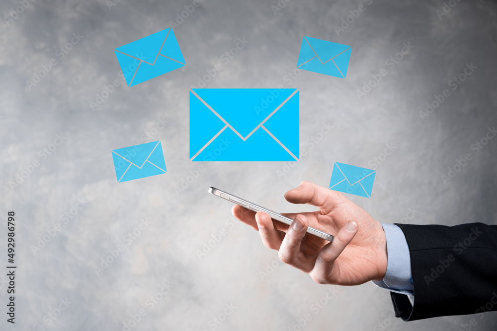 Businessman hand holding e-mail icon, Contact us by newsletter email and protect your personal information from spam mail. Customer service call center contact us concept Businessman hand holding e-mail icon, Contact us by newsletter email and protect your personal information from spam mail. Customer service call center contact us concept