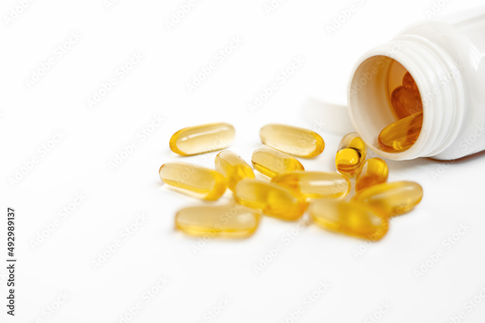 Omega-3 capsules lie in a jar (bottle) on a white background. Fish oil tablets. Biologically active additives. omega 6, omega 9, vitamin A, E, vitamin D, vitamin D3, evening primrose oil Omega-3 capsules lie in a jar (bottle) on a white background. Fish oil tablets. Biologically active additives. omega 6, omega 9, vitamin A, E, vitamin D, vitamin D3, evening primrose oil