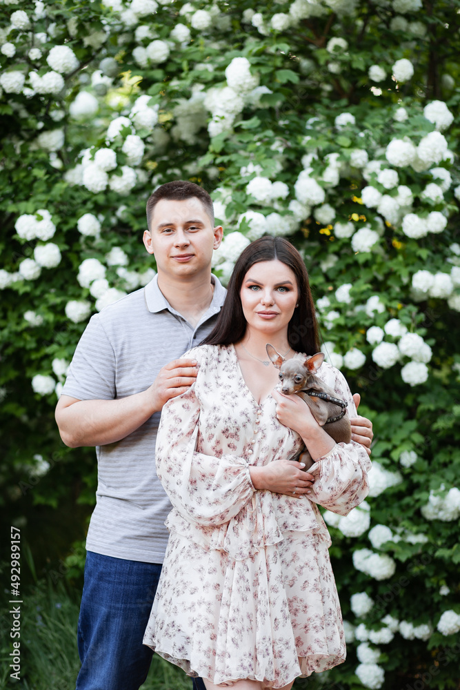 Happy Ukrainian couple in the park. Little dog, beautiful bouquet of tulips. spring freshness Happy Ukrainian couple in the park. Little dog, beautiful bouquet of tulips. spring freshness