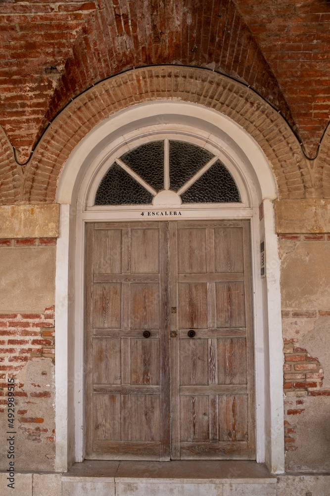 Ancient wooden door with lock in old stone wall.