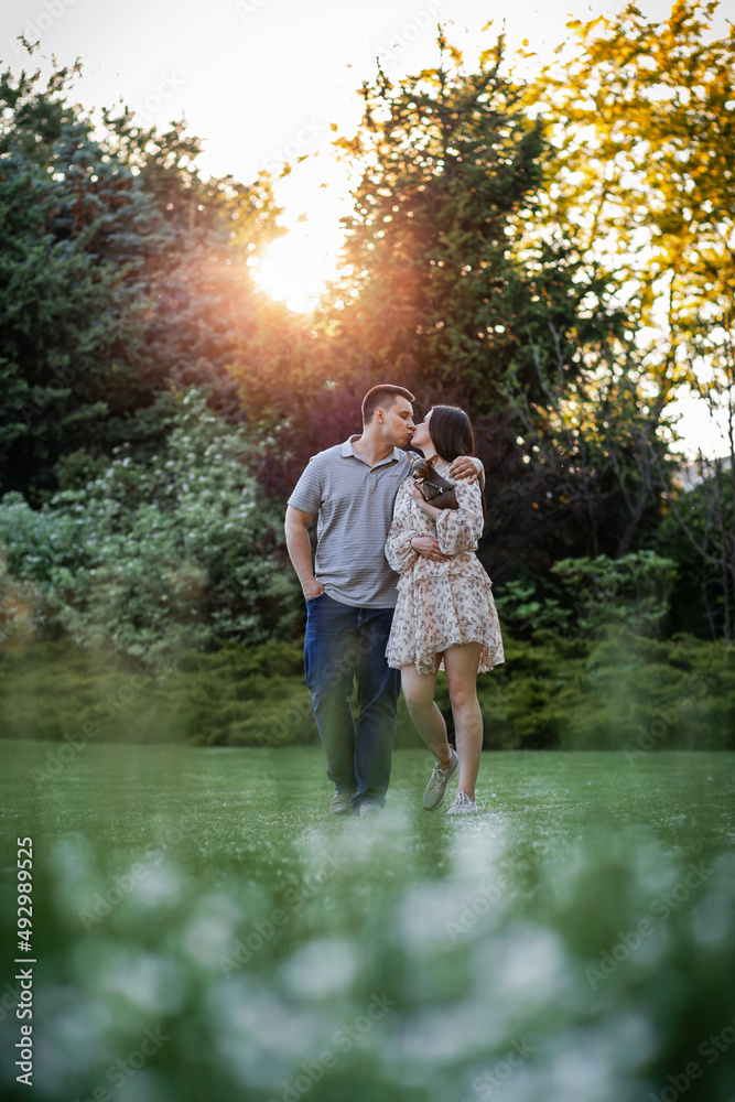 Happy Ukrainian couple in the park. Little dog, beautiful bouquet of tulips. spring freshness