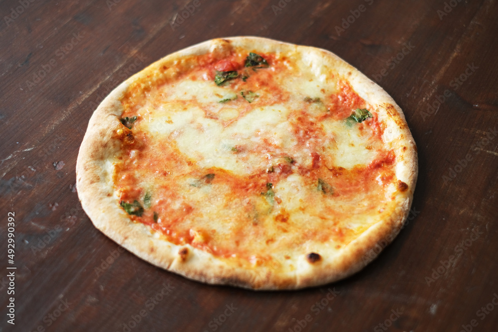 Fresh pizza with tomatoes, cheese and mushrooms on wooden table closeup
