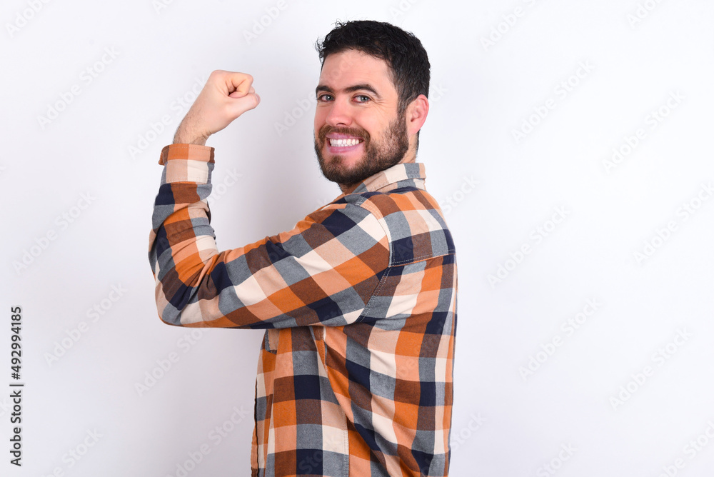 young caucasian man wearing plaid shirt over white background, showing muscles after workout. Health and strength concept. young caucasian man wearing plaid shirt over white background, showing muscles after workout. Health and strength concept.