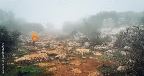 Young woman walking on stone path with fog. Limestone valley. Torcal of Antequera