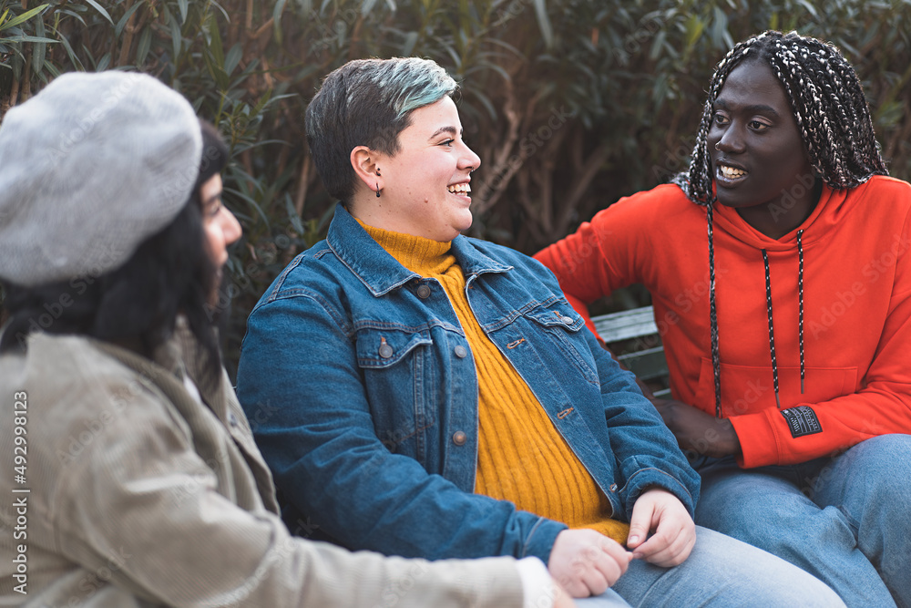 Different Races Talking Multiethnic group of women carefree talking together sitting on a bench ...