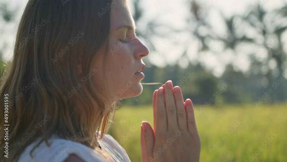 Pregnant woman stand at the field with green grass and fold her hands in pray. Sunshine summer vibes Pregnant woman stand at the field with green grass and fold her hands in pray. Sunshine summer vibes