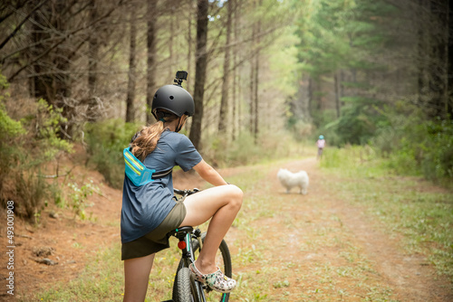 happy child girl riding a bike on natural background, forest or park. healthy lifestyle, family day out. High quality photo