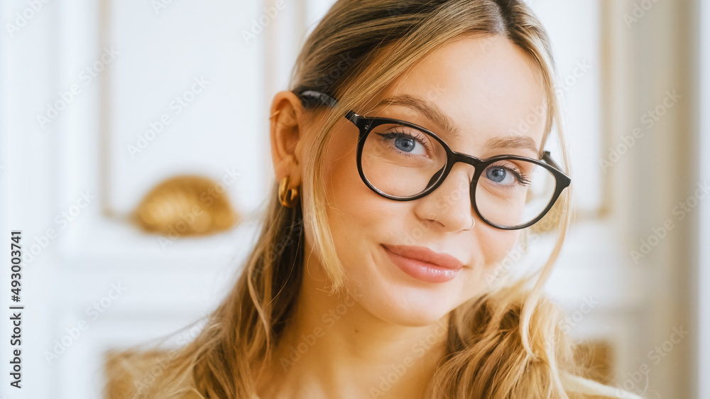 Portrait of happy smiling young attractive caucasian woman in eyeglasses looking on camera.	