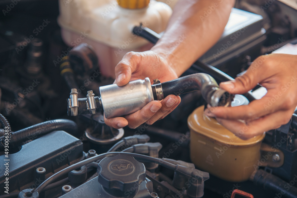 Close up Car Mechanic man hands repairing car auto repair shop. Man hands fixing machinery vehicle mechanical service. open vehicle hood checking up auto mobile. Vehicle Car maintenance engineer.