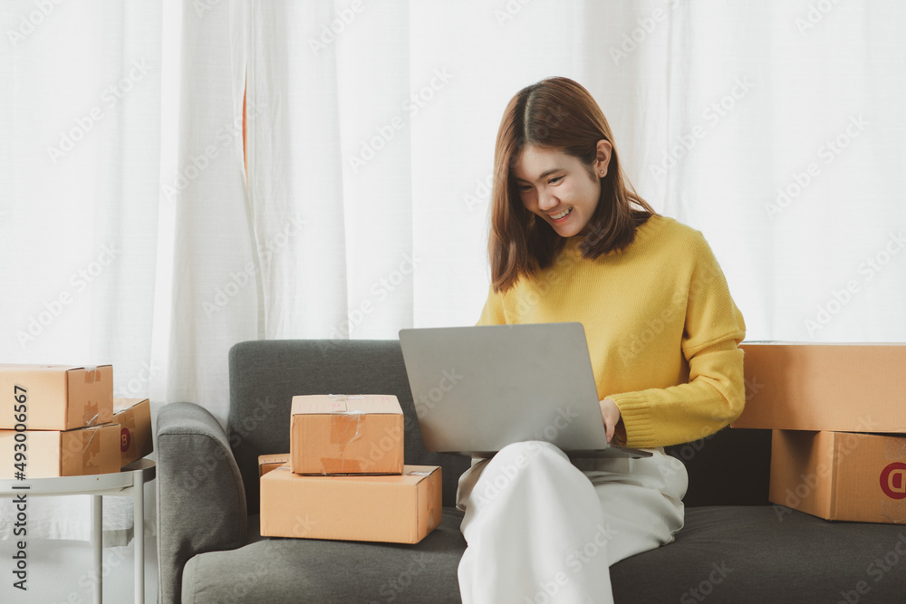 Asian Young woman owned business SME entrepreneur of Young Asian women working with Boxs laptop and phone for Online seller shopping at home, online marketing packaging delivery SME e-commerce concept Asian Young woman owned business SME entrepreneur of Young Asian women working with Boxs laptop and phone for Online seller shopping at home, online marketing packaging delivery SME e-commerce concept