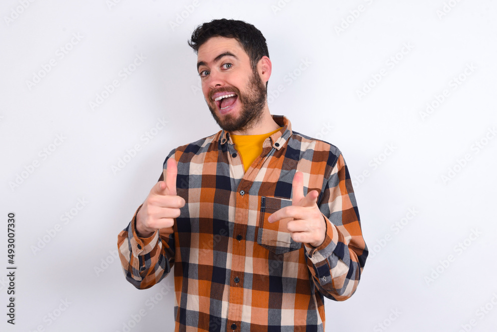 young caucasian man wearing plaid shirt over white background directs fingers at camera selects someone. I recommend you. Best choice young caucasian man wearing plaid shirt over white background directs fingers at camera selects someone. I recommend you. Best choice