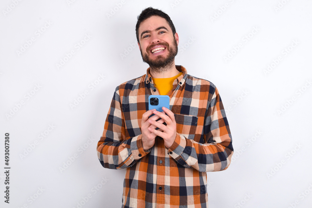 young caucasian man wearing plaid shirt over white background Mock up copy space. Using mobile phone, typing sms message young caucasian man wearing plaid shirt over white background Mock up copy space. Using mobile phone, typing sms message
